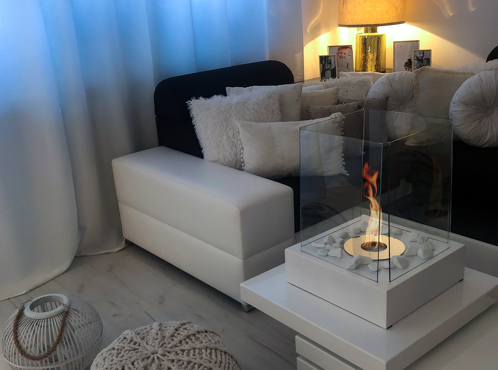 A freestanding Pure Fire bioethanol fireplace beside a soft, layered sofa